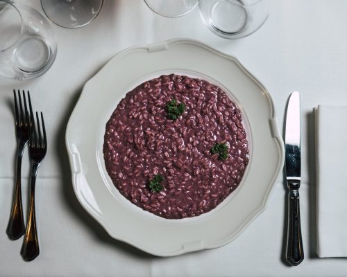 Risotto all’Amarone della Valpolicella DOCG mantecato con Monte Veronese, servito cremoso secondo l’antica ricetta veronese.